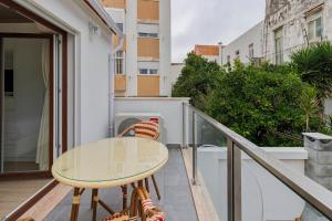 a balcony with a table and chairs on it at Setúbal Serenity Villa I, By Home Match in Setúbal