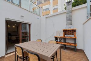 a table and chairs on a balcony with a fireplace at Setúbal Serenity Villa I, By Home Match in Setúbal