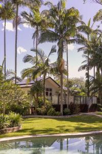 a house with palm trees and a swimming pool at Sunrise Guesthouse in Byron Bay