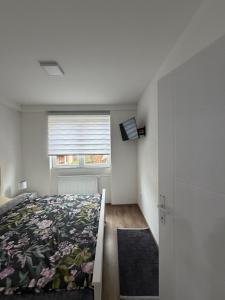 a bedroom with a bed and a window at Apartman AURORA Trstenik in Trstenik