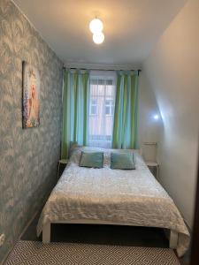 a bedroom with a bed with two pillows and a window at Sunny Hostel 49 in Wrocław