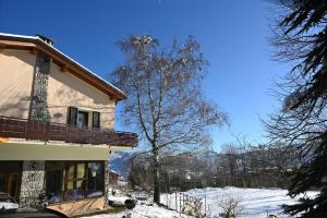 a house in the snow with a tree at Ca' Tra Cielo e Monti in Frassinoro