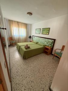 a bedroom with a green bed and a chair at Los Ficus in Playa del Ingles
