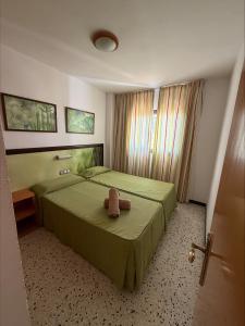 a bedroom with a bed with a teddy bear on it at Los Ficus in Playa del Ingles +32 photos