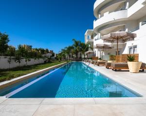 a swimming pool in front of a building at Evita in Faliraki