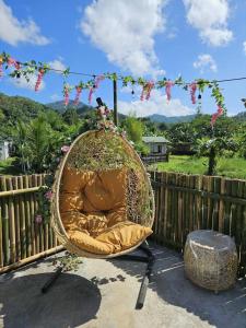 a hanging basket chair with flowers on a fence at Tony nature place in Antipolo