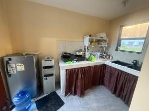 a small kitchen with a refrigerator and a sink at Tony nature place in Antipolo