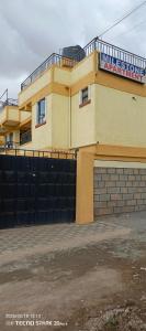 a yellow building with a sign on top of it at Savannah milestone in Gilgil