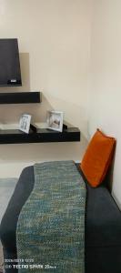 a room with a couch with an orange pillow at Savannah milestone in Gilgil