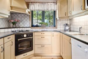a kitchen with white cabinets and a black oven at Mountain Cabin With Great Views in Austbygdi