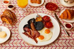 a plate of breakfast food on a table at Haymarket Hotel, Firmdale Hotels in London +15 photos