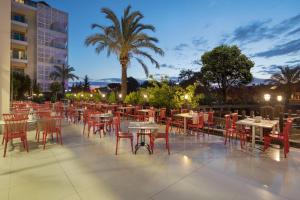 a patio with tables and chairs at night at Grand Ring Hotel in Beldibi