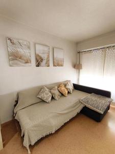 a couch in a living room with paintings on the wall at Estudio Petrer in Petrer