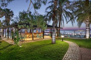 a park with palm trees and a restaurant at Grand Ring Hotel in Beldibi