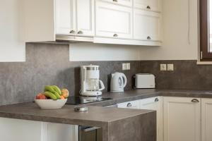 a kitchen with white cabinets and a bowl of fruit on a counter at Villa Nina with Private Pool in Kolymvari