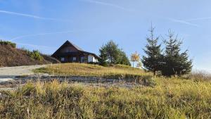 a house sitting on top of a grassy hill at Zrubová chata Jakub in Oravská Lesná