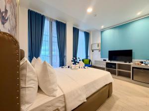 a bedroom with a bed with a television and blue curtains at PlayaLolita Beach Resort in Calatagan