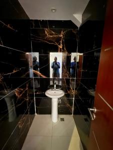 a man taking a picture of a bathroom with a sink at Sylla in Dakar