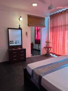 a bedroom with a bed and a flat screen tv at Rock House Villa in Kandy