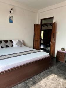 a bedroom with a bed and a wooden door at Rock House Villa in Kandy