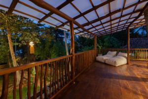 a covered porch with two pillows on a wooden deck at La Cove in Matara
