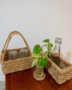 a basket and a bottle and a vase with a plant at La Cove in Matara