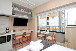 a bedroom with a bed and a kitchen with a table at Raízes Studios Tatuapé – Mitre 4 in São Paulo