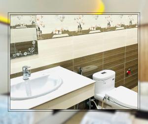 a bathroom with a sink and a toilet and a mirror at Sunny 1 Hometel Vinh Long in Vĩnh Long +44 photos