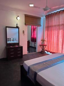 a bedroom with a bed and a flat screen tv at Rock House Villa in Kandy