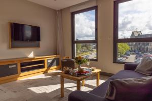a living room with a couch and a tv at Hotel Le Cercle in Cherbourg en Cotentin