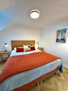 a bedroom with a large bed with a red blanket at Canopée - Appartement - Hyper centre ville in Quimper