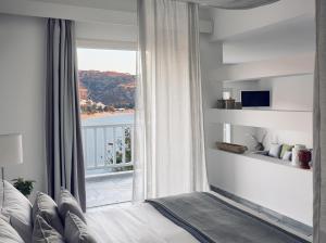 a bedroom with a bed and a large window at Ios Palace Hotel & Spa in Mylopotas