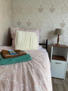 a bed with a blanket and a pillow and a table at Pension EdHeLo in Barby