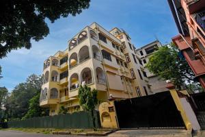 a yellow and white building with a fence in front of it at Hotel Soft Petal BB Block in Kolkata