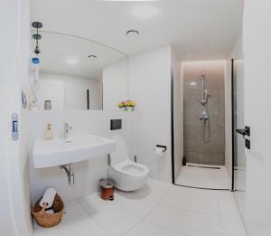 a bathroom with a sink and a toilet and a shower at Jasminn Apartments in Prague +56 photos