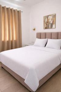 a large white bed in a bedroom with a window at White Rocks Meteora in Kalabaka