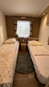 two beds in a small room with a window at Andes in Dronrijp