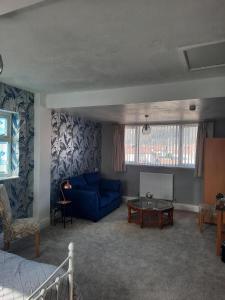 a living room with a blue couch and a table at Rosaire Guest House in Llandudno +52 photos