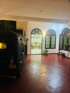 a black van parked in a room with a bed in the window at Senuka Villa in Mirissa