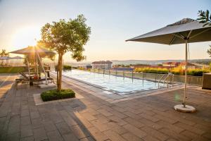 a swimming pool with umbrellas and tables and a pool at Ad Astra Studio Apartment - Waterfall in Midrand