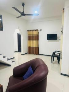 a brown couch in a living room with a ceiling fan at Senuka Villa in Mirissa