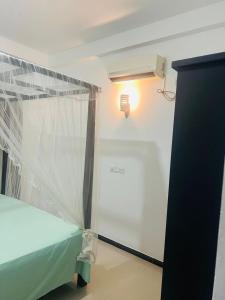 a room with a bed and a light and a window at Senuka Villa in Mirissa
