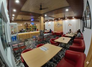 a restaurant with tables and chairs and people sitting at tables at Hotel Krishna And Restaurant in Sonprayag