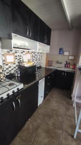 a large kitchen with black cabinets and a stove at Theodora Hostel in Istanbul +33 photos