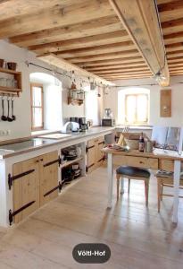 a large kitchen with wooden cabinets and a table at Völtl-Hof in Büchlberg