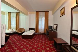 a hotel room with a red carpet and a living room at Hotel Magic GT Trivale in Piteşti