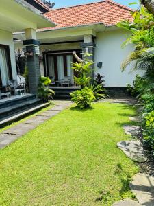 a house with a green lawn in front of it at Villa Reisya in Nusa Dua
