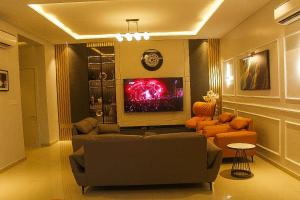 a living room with couches and a flat screen tv at Dalos Unit in Ilado