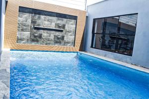 a swimming pool next to a building with a large window at Dalos Unit in Ilado