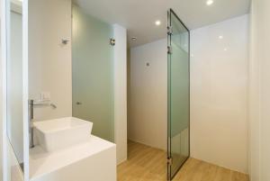 a bathroom with a sink and a glass shower at Glyfada Glow Suites by CorfuEscapes in Glyfada +44 photos